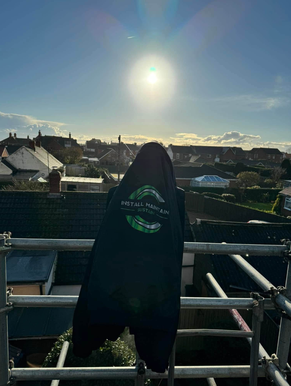 IMS engineer on scaffolding overlooking residential rooftops
